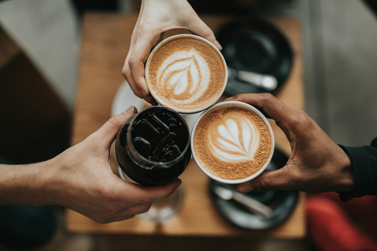 Tasse und aufgeschlagenes Heft auf einem Tisch bei warmem Licht